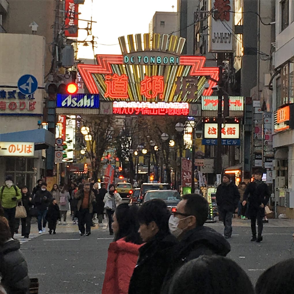 A neon sign lit up at night at the beginning of Dotonbori street, one of the most well known areas of Osaka