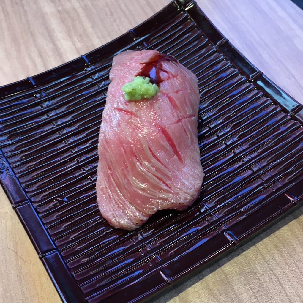 A serving of Kobe beef sashimi on a brown plate