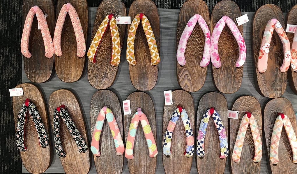 A variety of wooden geta shoes for sale, neatly arranged into rows.