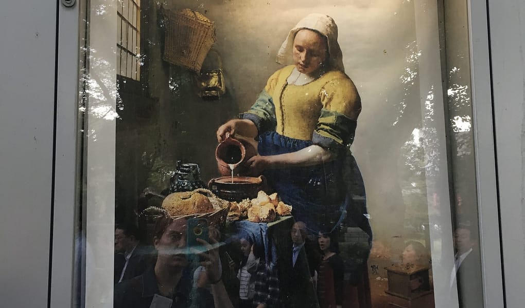 A flier encased in glass advertising the Vermeer and Dutch art exhibit