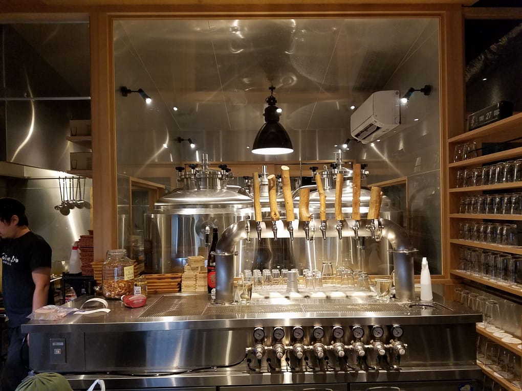 The bar area of Kyoto Beer Lab. Stainless steel taps line the bar