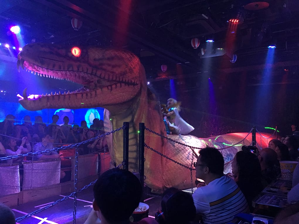 Animatronic snake with a rider comes from the right side of the stage