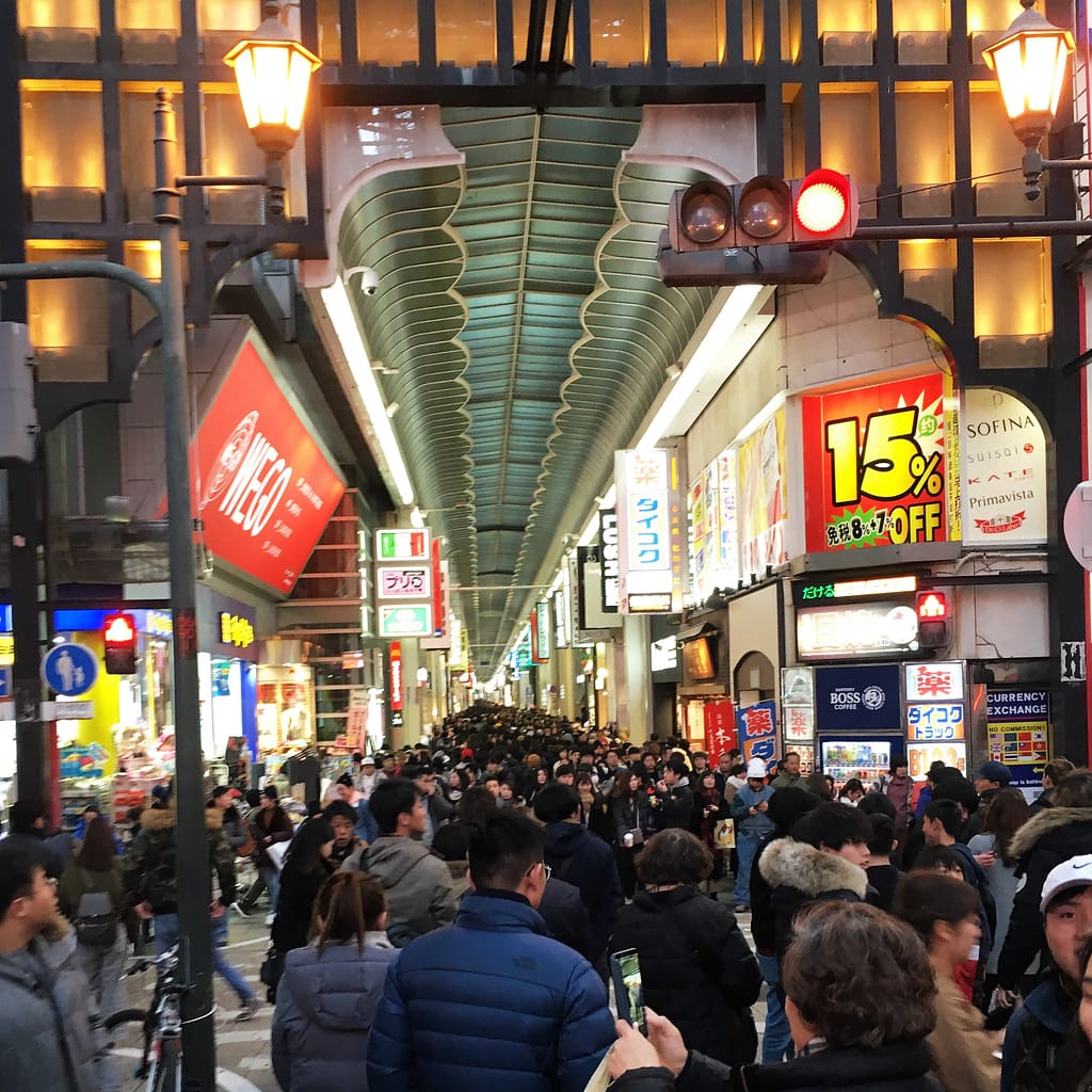 A view of Shinsaibashi shopping street. Shoppers go as far as the eye can see down a covered shopping area