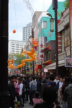 Yellow lanterns shaped like a dragon hang above the busy streets of Yokohama's Chinatown