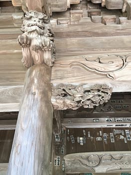 A lion decorates a column capital on the temple facade