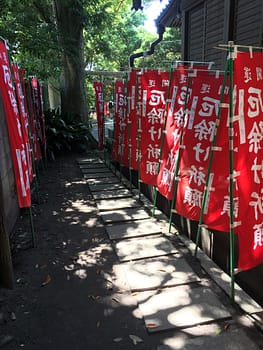 A walkway surrounded by red flags leads to way to the shrine.