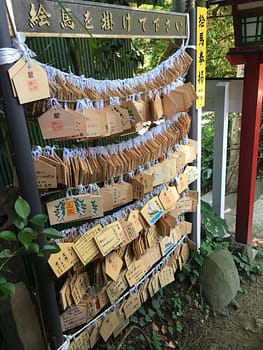 A large display of wooden ema hanging outside the shrine