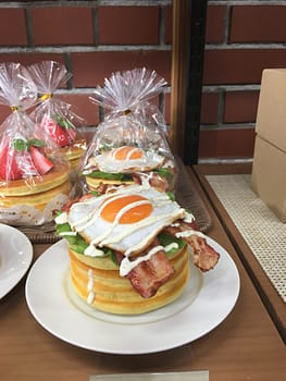 Plastic food - a short stack of pancakes, topped with bacon and a fried egg