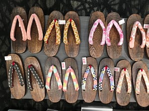 A variety of wooden geta shoes for sale, neatly arranged into rows.