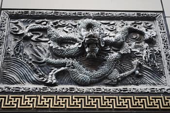A dragon carved in relief above a door to a building