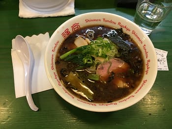 A bowl of ramen in black soup