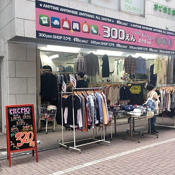 The exterior of 300 yen thrift store has racks of clothing outside.