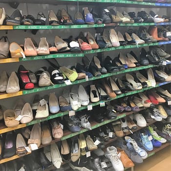 A large selection of used shoes for sale at Book Off Super Bazaar thrift store. The photo shoes seven rows of shelves of women's shoes.