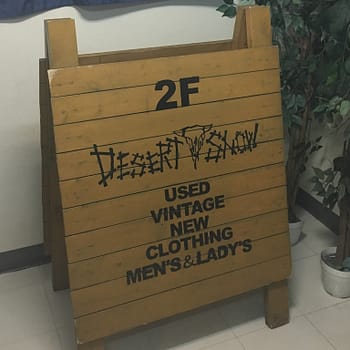 A wooden A-frame sign sits outside the thrift store Desert Snow