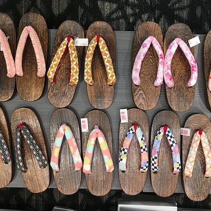 A variety of wooden geta shoes for sale, neatly arranged into rows.