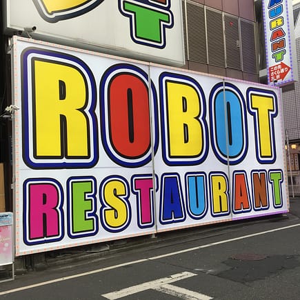 Colorful signage pointing the way to Robot Restaurant in Shinjuku