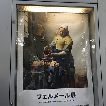A flier encased in glass advertising the Vermeer and Dutch art exhibit