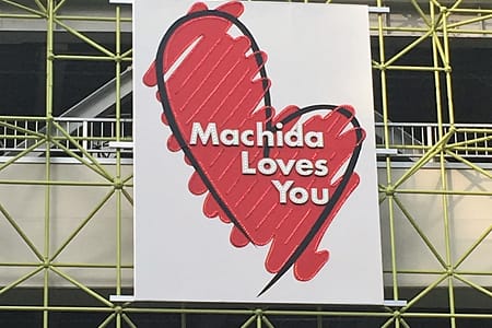 A public sign with a lopsided, hand drawn heart that reads "Machida Loves You"