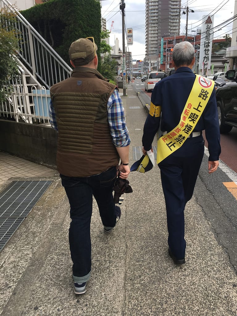 Expect hospitality. This image shows husband and a Japanese train station employee walking down the street
