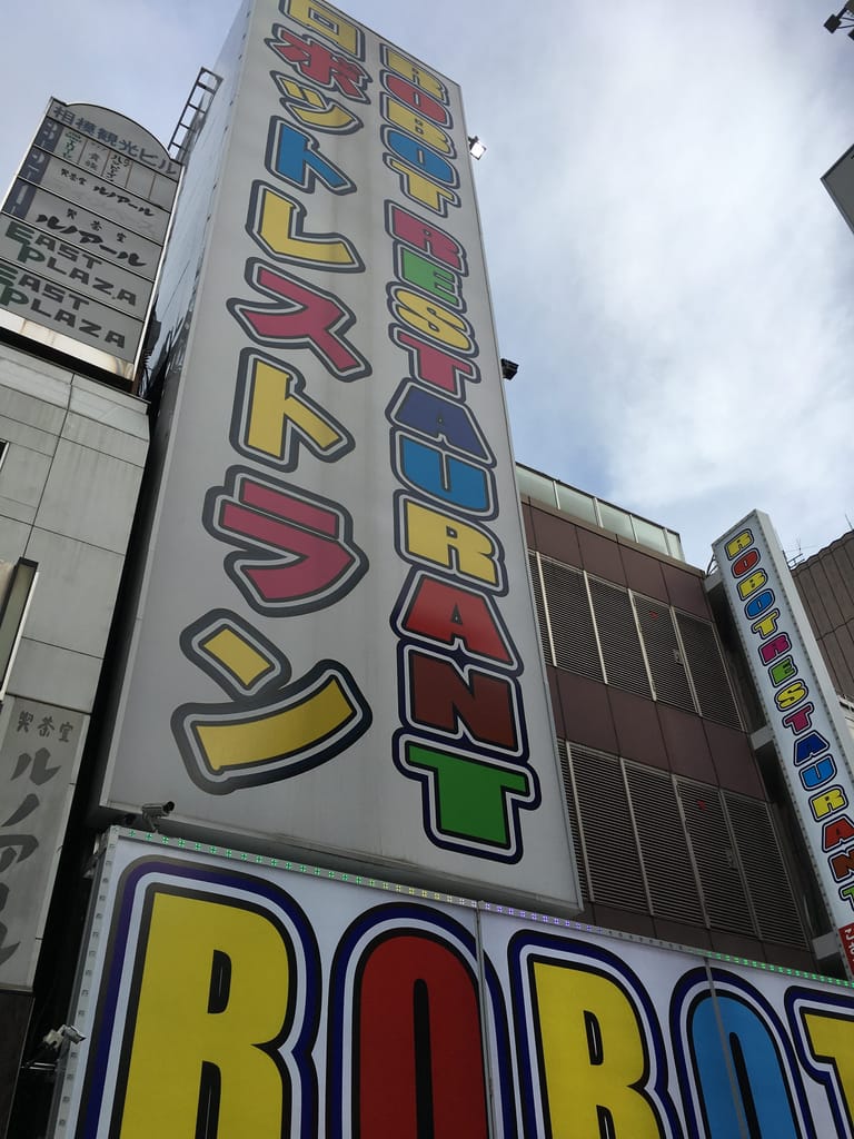 Colorful signage pointing to way to Robot Restaurant in Shinjuku