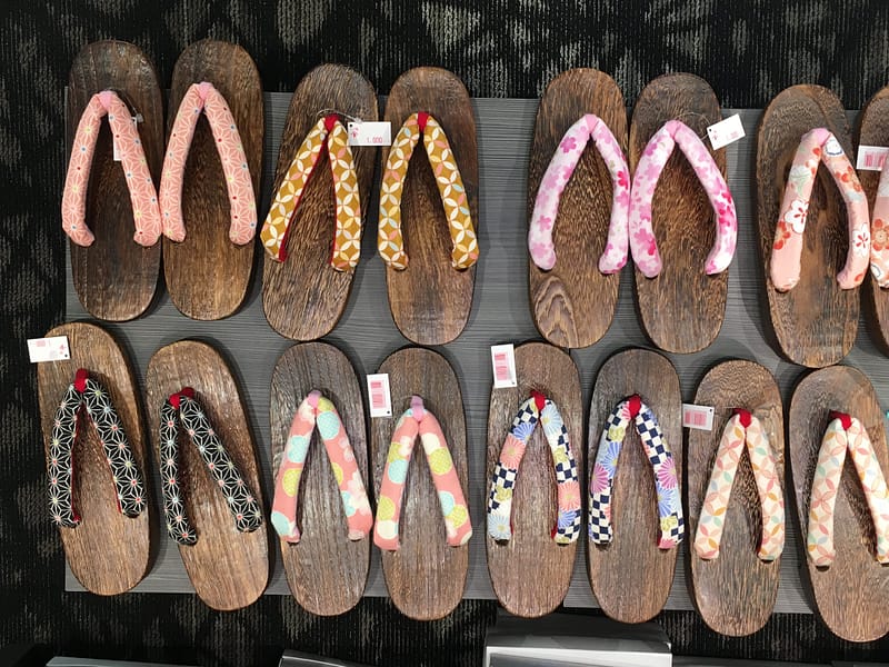 A variety of wooden geta shoes for sale, neatly arranged into rows.